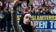 Viral: Hijab-clad woman clicks selfies next to anti-Muslim protesters, wins the internet 