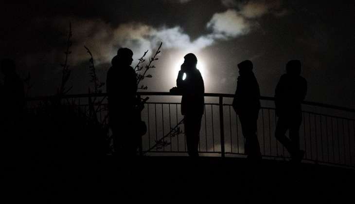 New Zealand residents stand near the top of Mt Victoria, the highest hill in Wellington on early 14 November 2016, following an earthquake centred some 90 kilometres north of New Zealand's South Island city of Christchurch