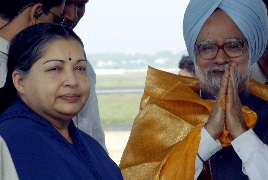 Prime Minister Manmohan Singh greets people as chief minister of Tamil Nadu J Jayalalithaa looks on, upon his arrival at the city airport, on 23 October 2004 in Chennai, India.