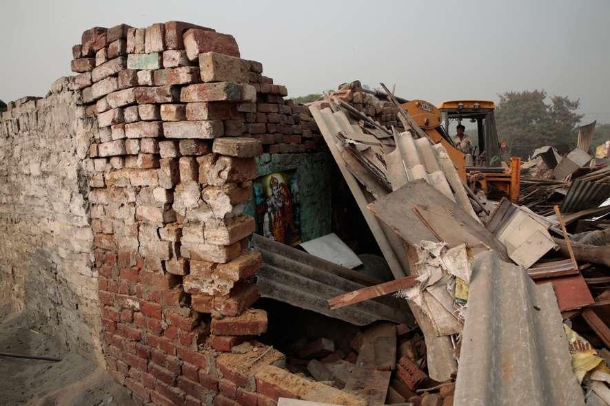 A bulldozer demolishes a structure in Mehrauli. The MCD demolished a slum in Mehrauli, New Delhi that left almost 1500 people homeless.