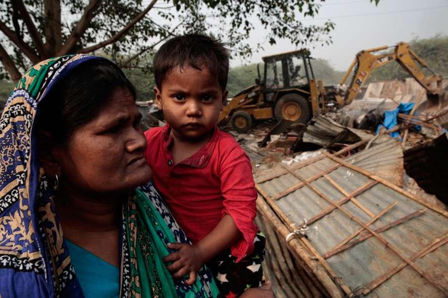 Slum dwellers watch as their homes get demolished. The MCD demolished a slum in Mehrauli, New Delhi that left almost 1500 people homeless.