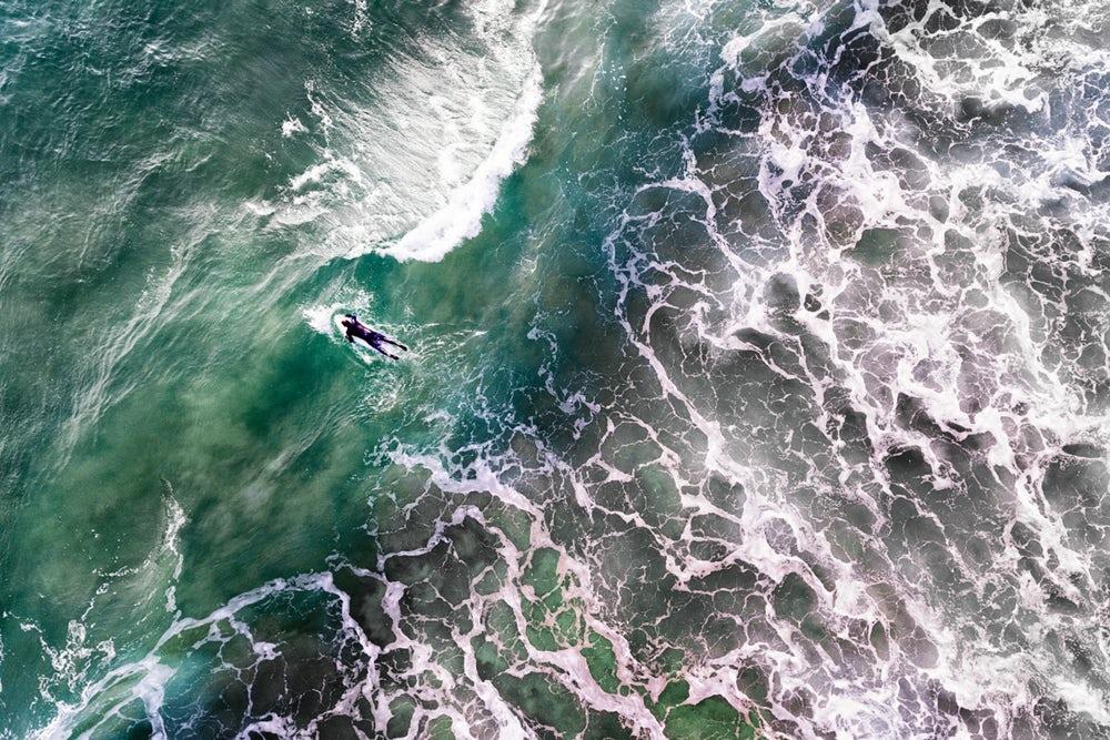 Stunning drone shot of a surfer in Portugal