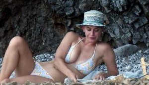 Katy Perry flaunts her bikini body in a stripy bikini on the beach in Spain
