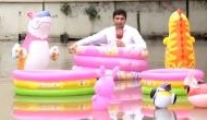Watch Video: Pakistani reporter sits floating tube on flooded road to cover heavy rainfall 