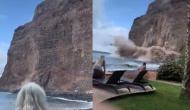 समुद्र किनारे मस्ती कर रहे थे पर्यटक तभी पानी में आ गिरी ऊंची चट्टान, वीडियो में देखें फिर हुआ क्या
