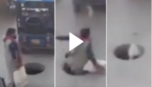 Woman falls into manhole while talking on phone; shocking video goes viral