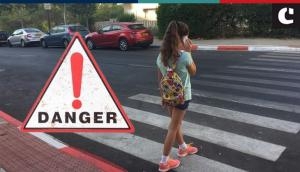 Talking on mobile phone while walking on road can be dangerous; this viral clip is a proof