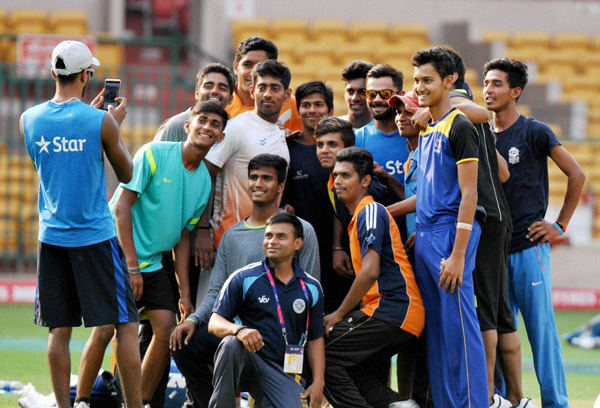 Bengaluru: Cricketer Virat Kohli poses with young cricketers as Hardik Pandya  clicks their photo du