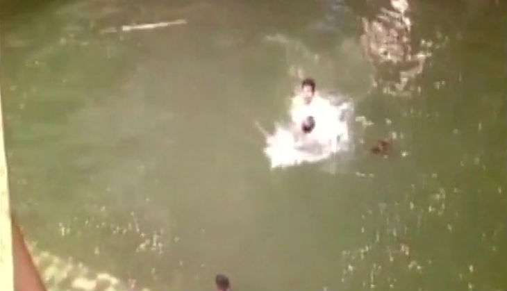 Ganesh mandal volunteer holds police man's head under water during Ganesh festival 