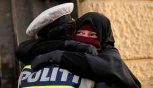 Cop hugging a woman wearing burka